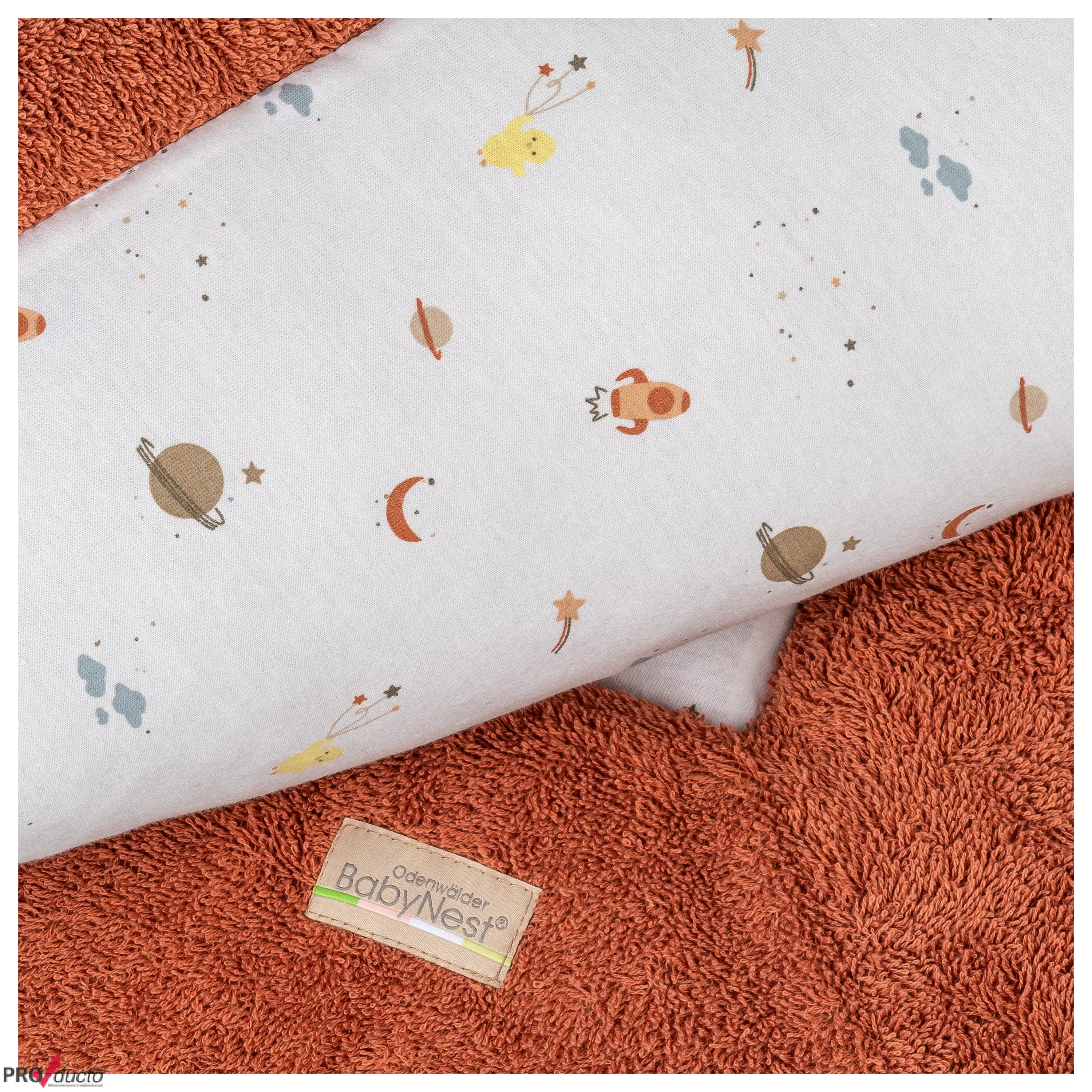 Professionelle Produktfotografie von BabyNest Textilien mit Weltraum-Muster auf weichem, rostfarbenem Frotteestoff.
