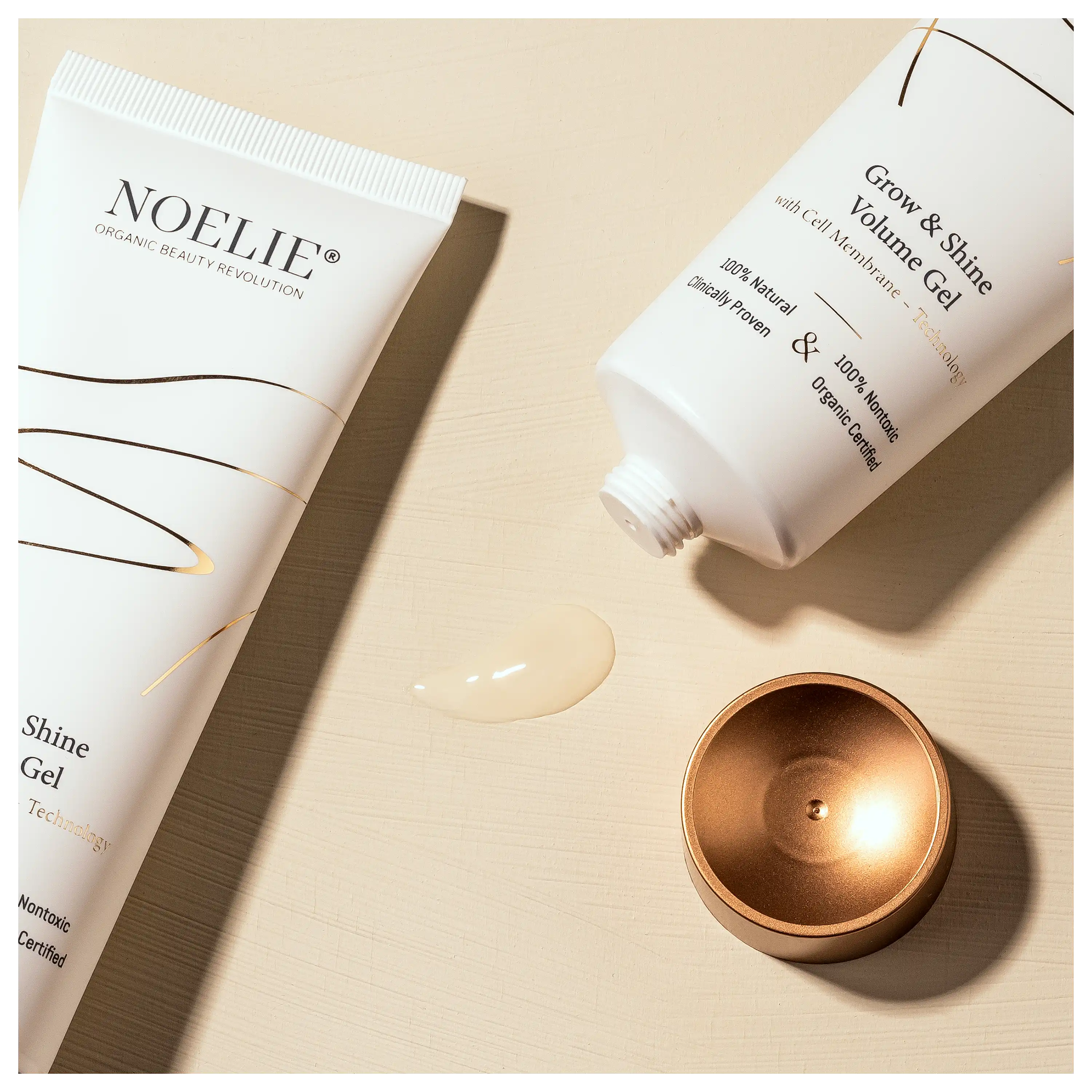 Professionelle Produktfotos von NOELIE Grow & Shine Volume Gel Tuben mit Textur auf beigem Hintergrund.