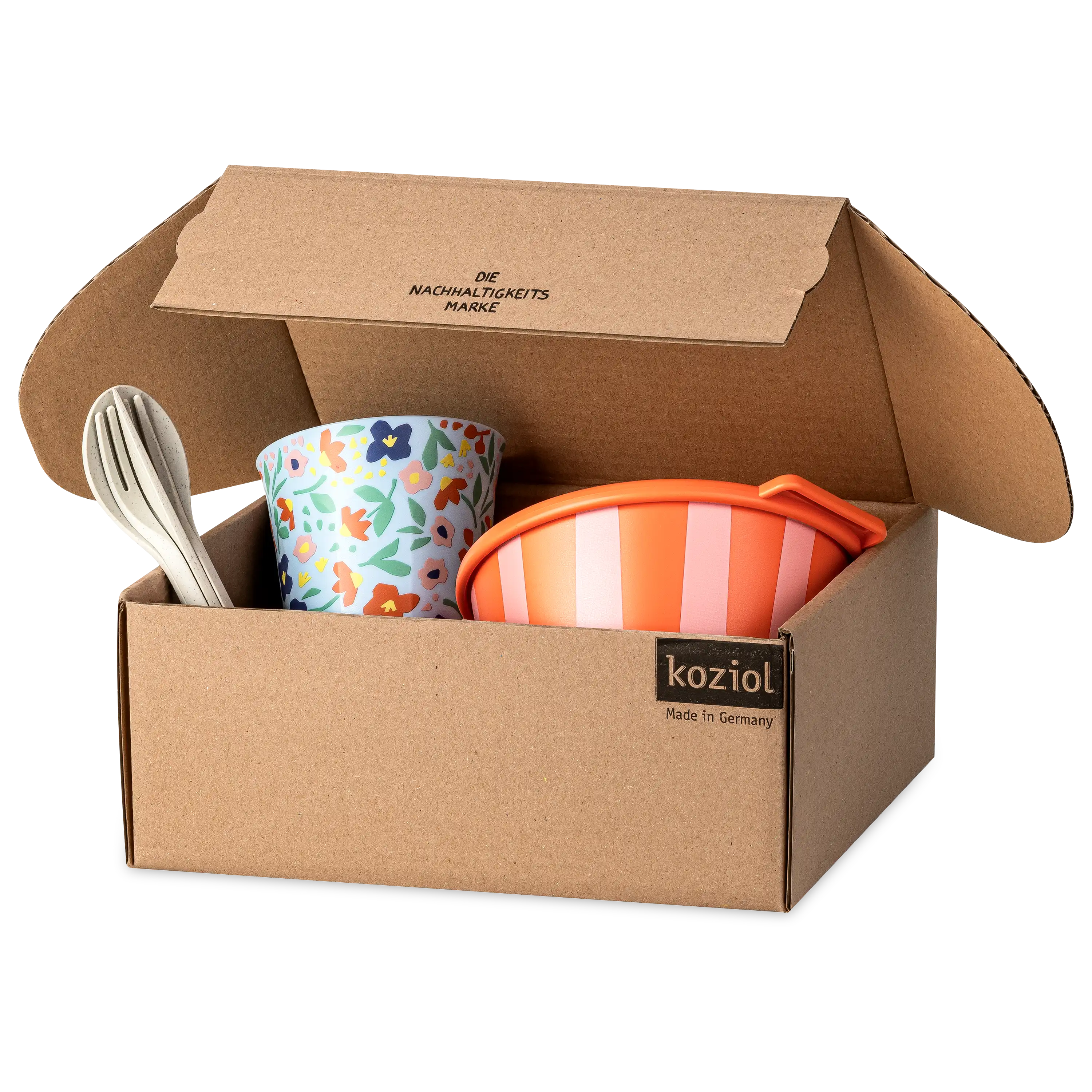 Offener Karton von koziol mit buntem Becher, orangefarbener Schüssel und Besteck für professionelle Produktfotos.