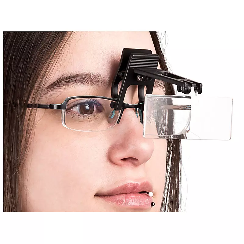 Eine Person trägt eine Brille mit einer daran befestigten Lupenvorsatz-Linse für präzise Arbeiten, fotografiert von der PRO-ducto GmbH.