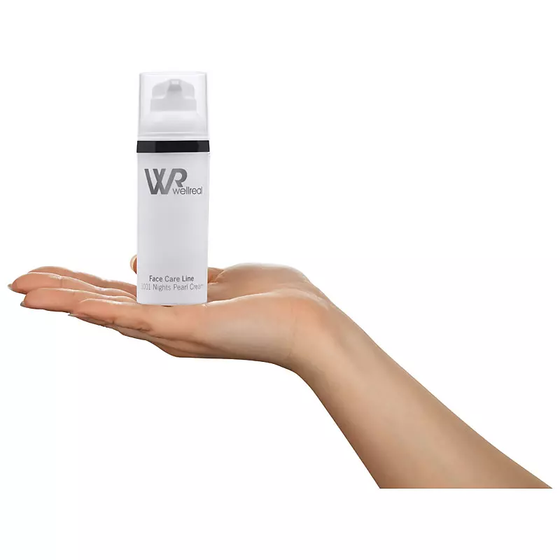 Eine Hand präsentiert einen weißen Spender der Wellreal Face Care Line. Professionelle Produktfotos von PRO-ducto GmbH für hochwertige Kosmetik.
