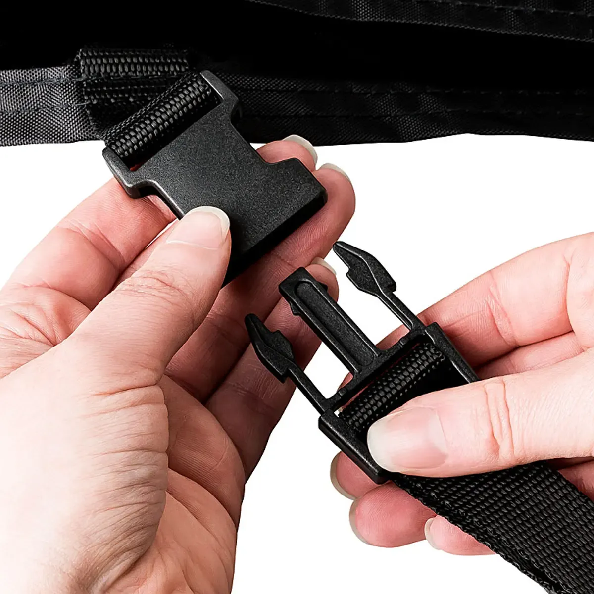 Professionelle Produktfotografie: Hände schließen eine schwarze Steckschließe an einem Textilband, ideal für hochwertige Produktbilder erstellen. PRO-ducto GmbH
